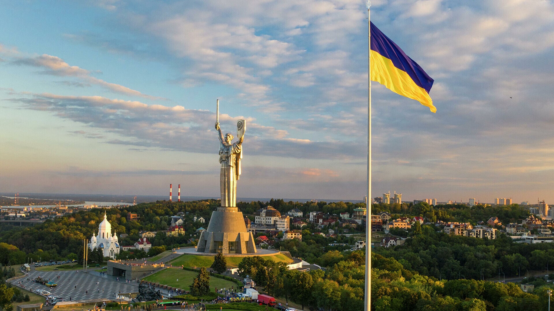 Україна-мать і державний прапор над Києвом у золотому світлі світанку